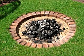 CIRCULAR BRICK BARBQ WITH SAND IN LAWN