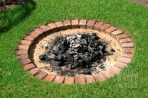 CIRCULAR_BRICK_BARBQ_WITH_SAND_IN_LAWN