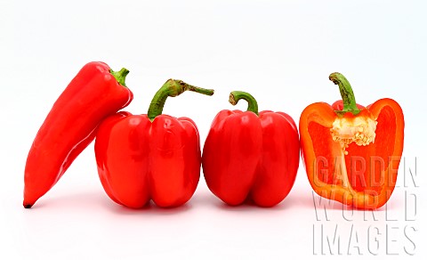 Few_red_ripe_sweet_peppers_and_one_pepper_in_a_cut_on_a_light_background_Natural_product_Natural_col
