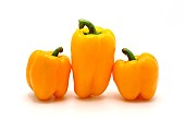 Three ripe sweet peppers of yellow color on a light background. Natural product. Natural color. Close-up.