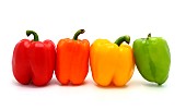 Four ripe sweet peppers on a light background. Red, yellow, green and orange. Natural product. Natural color. Close-up.