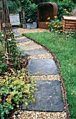 GRAVEL PATH WITH PAVING INSETS,  WITH OBELISK,  WICKER SEAT AND BEE HIVE,  WATTLE EDGING.