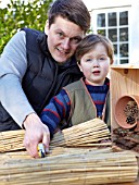INSECT HOUSE BUILDING PROJECT WITH FATHER AND SON.  CUTTING BAMBOO INTO SMALL BUNDLES.  STEP 30