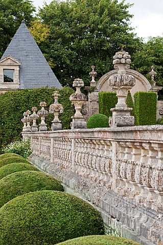 BUXUS_SEMPERVIRENS__IN_FORMAL_PARTERRE_GARDEN_WITH_STONE_BALUSTRADE_AND_ORNAMENTAL_CARVINGS_AT_CHATE