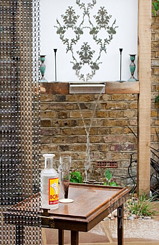 THE_DRAWING_ROOM_GARDEN__URBAN_LONDON_GARDEN__WATER_FEATURE_BEHIND_CHAIN_SCREEN_WITH_FILIGREE_PATTER