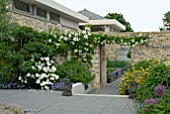 MODERN WALLED GARDEN WITH WHITE ROSES AND HERBACEOUS BORDERS LOOKING THROUGH TO KITCHEN GARDEN