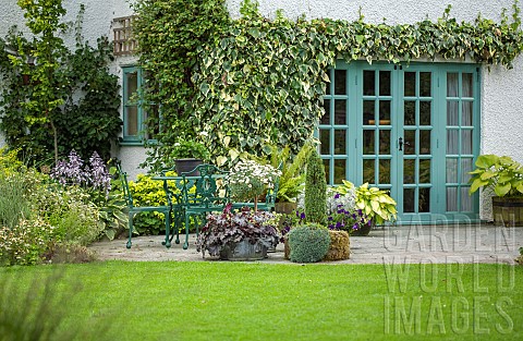 Patio_area_green_wrought_iron_table_and_chairs_with_views_across_lawns_to_borders