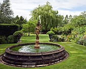 Rectangular water fountain with statue of boy in centre of lawn