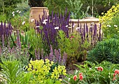 Summer flowering herbaceous perennials large ornate containers in gravel