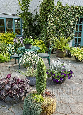 Patio_area_at_Lilac_Cottage_NGS_Staffordshire_green_wrought_iron_furniture_variety_of_pots_planted_u