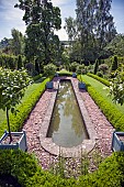 Semi Formal Garden Long canel edged with box hedge and tall planters