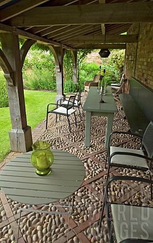 Tables_and_chairs_under_the_loggia_with_oak_arches_and_cobbled_floors