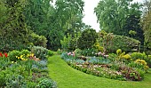 Borders of herbaceous perennials, spring bulbs, and flowers, shrubs and many mature trees