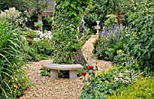 SMALL STONE BENCH IN A PERENNIAL GARDEN. DESIGN: MARIANNE AND DETLEF LUEDKE